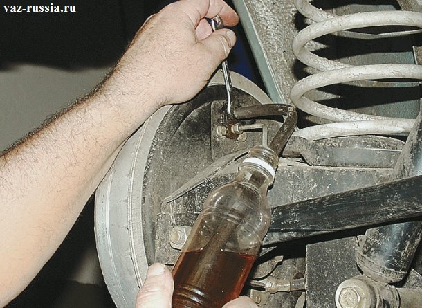 Ослабление штуцера заднего колеса и тем самым выливание отработанной тормозной жидкости в бутылку
