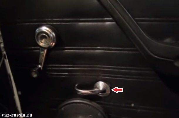 Стрелкой указано место в котором облицовку ручки открывания достаточно поддеть и после чего её можно будет снять с машины